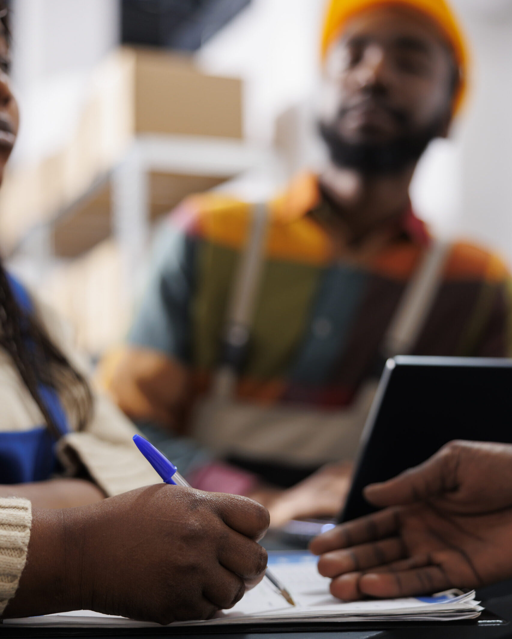 warehouse worker hand writing in clipboard at reception desk